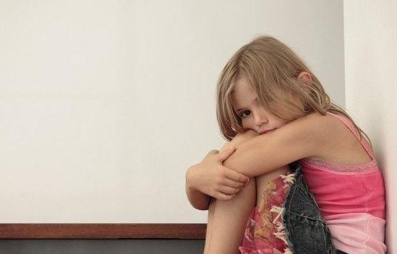 A parent and child talking warmly, the parent kneeling to be at eye level