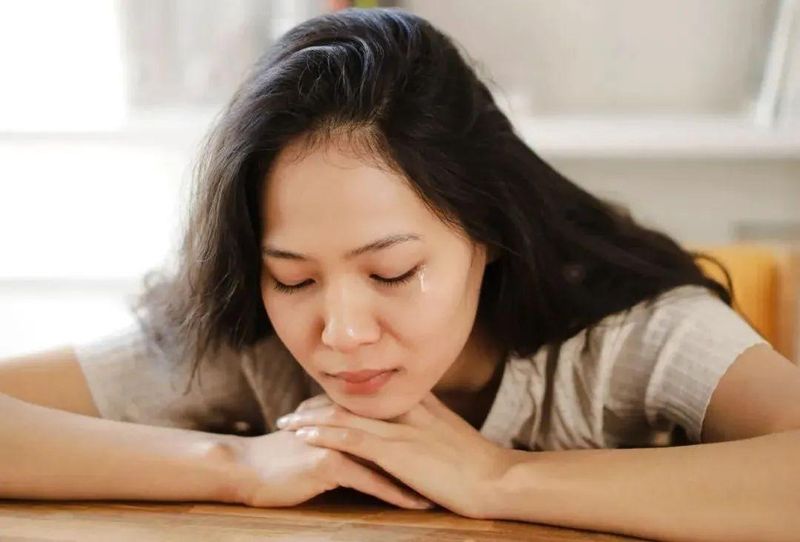 A close-up of a mother's worried expression, deep in thought